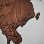 Detailed wooden map art showcasing countries in Asia with carved region names.